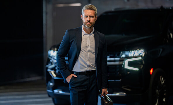 Corporate business. Rich businessman in suit. Business portrait. Successful businessman standing with briefcase in parking. Businessman hold briefcase. Handsome businessman in suit