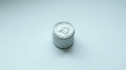 A white, round jar of moisturizer sits on a white, textured surface, with the lid removed and the creamy contents partially visible