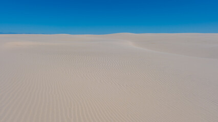 Vast stretches of white sand create a tranquil atmosphere in this coastal region of Denmark. The gentle dunes and endless horizon evoke a sense of peace and natural beauty. Rabjerg Mile dunes