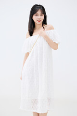 Studio shot of beautiful Asian woman in white dress