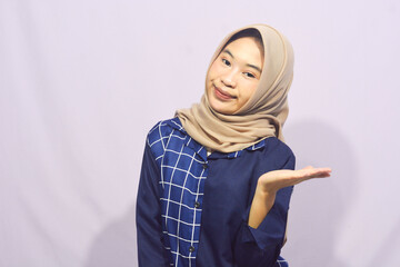 Beautiful young student girl wearing green student t-shirt smiling happily pointing with hand and finger to the side on isolated purple background