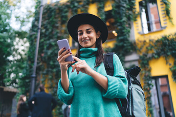 Brunette woman, 30, reads her smartphone screen with focus and joy, showing natural interaction with technology as part of daily digital habits and fluency.
