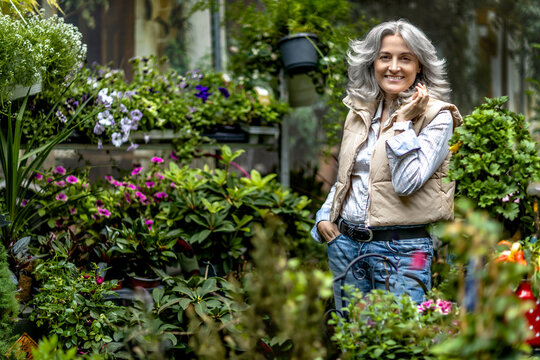 Portrait of a 50 year old woman in the yard of an ornamental flower store