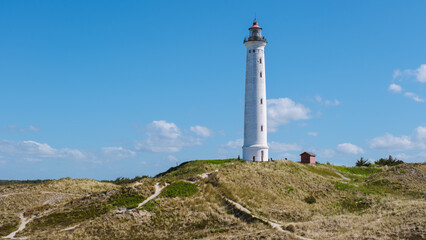  Lyngvig lighthouse Denmark, stands tall against a brilliant blue sky.