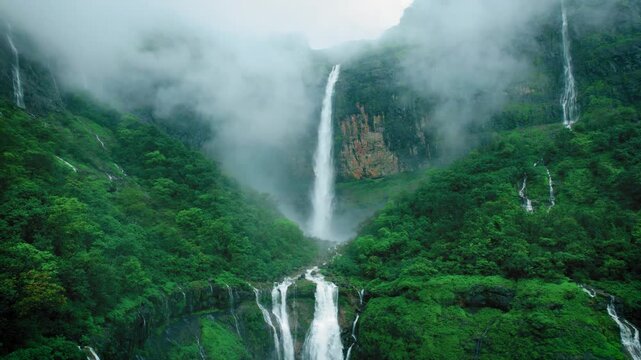4K Aerial shot of mesmerising Nanemachi waterfall falling from cliff in Sahyadri hills during monsoon season at Maharashtra, India. Drone view of powerful waterfall in lush green forest landscape. 