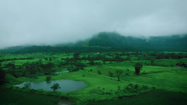 4K Aerial shot of lush green landscape of Sahyadri hills and dark rainy clouds in sky. Sahyadri ranges of western ghats of Maharashtra, India. Monsoon aerial nature landscape.