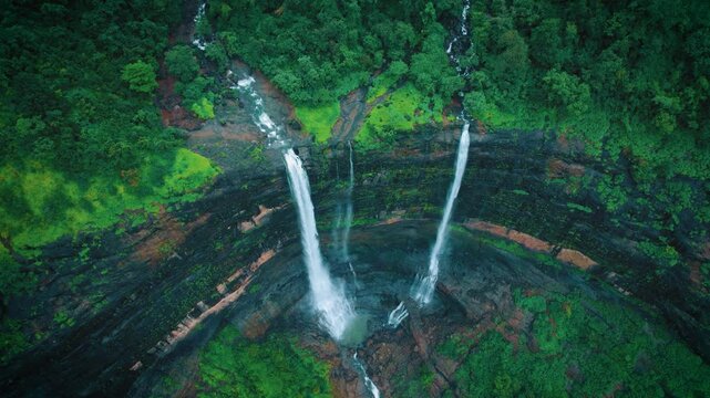 4K Aerial view of Kataldhar waterfall falling from Sahyadri hills in Lonavala, Maharashtra, India. Top down view of waterfall during monsoon season. Lush green landscape, Nature and travel concept.