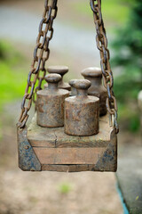 Close-up view highlights the textured wood and rusted chains of an antique balance, suggesting a bygone era of trade and measurement.