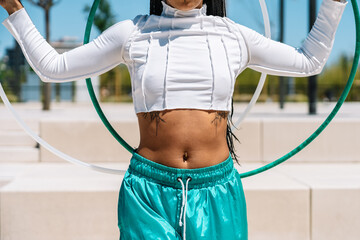 Young woman performing with hula hoops in urban setting