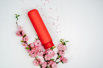 Shampoo, hair conditioner in a red jar on a white background. Mockup, space for text. Sakura...