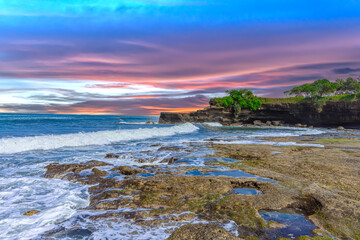 Tanah Lot Temple on the island of Bali known as the island of Gods. Sitting on top of rock island over looking turquoise blue beaches in Bali Indonesia