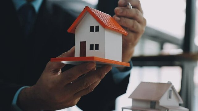 Lawsuits against Real estate agent and realtor general liability insurance businessman professional discussing and consultant with house toy model building before sign a contract with law concept