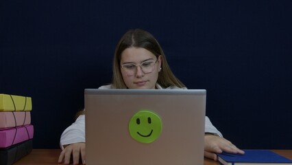 Woman Working at Desk with Laptop, Papers, and Colorful Binders