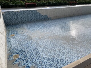 A swimming pool under repair, an abandoned swimming pool with no water in it