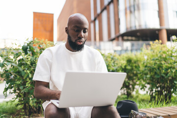 Focused young man interacts with laptop, symbolizing concentration, modern learning and full...
