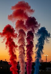 Colorful Smoke Plumes at Sunset - Vibrant red, pink, white, and blue smoke plumes rise against a stunning sunset backdrop
