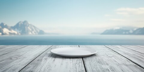 Deck feast mountains concept. Empty plate on a wooden table with mountains and water in the background, creating a serene atmosphere.