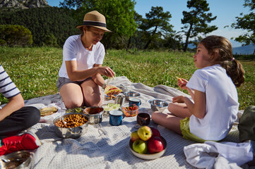 Family Enjoying a Picnic in the Mountains Surrounded by Scenic Nature