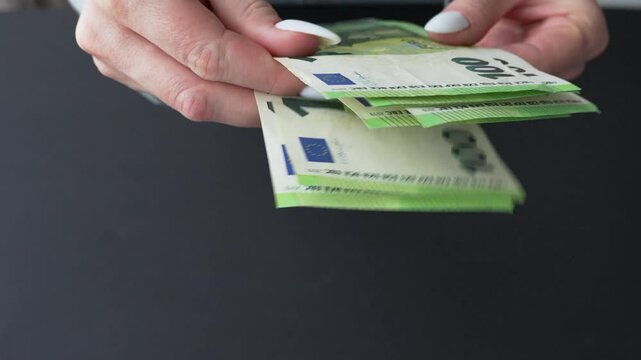 Women's hands counting money. 100 euro notes