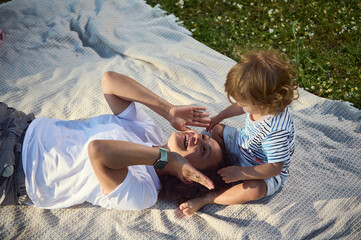Mother and Child Sharing Moments on a Picnic Blanket Outdoors