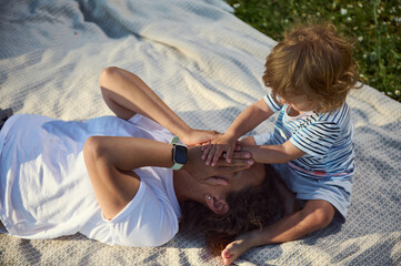 Mother and Child Enjoying Quality Time Together Outdoors on a Blanket