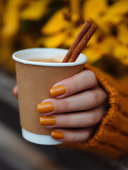 Warm autumn touch with a cozy drink amidst golden foliage in a tranquil outdoor setting
