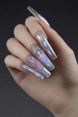Elegant long holographic nails showcase modern nail art techniques, glimmering in the light with intricate details