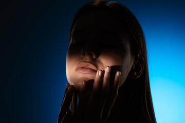 Obraz premium Captivating Portrait with Dramatic Shadow Play and Light Beam