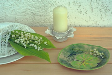 A small bouquet of lilies of the valley in a white lace napkin on the table