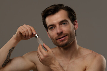 Man Applying Skincare Serum with Dropper for Smooth Complexion
