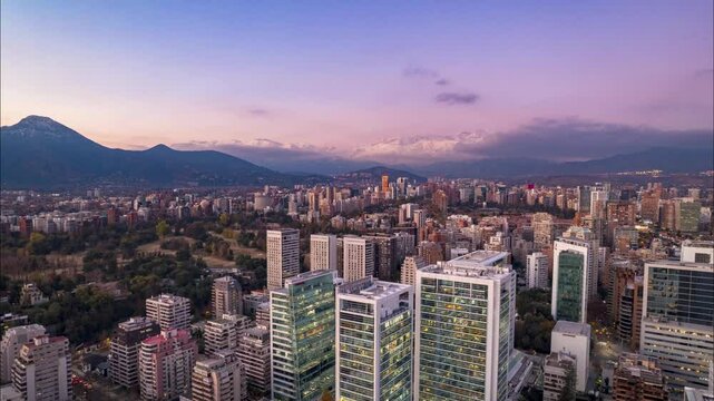 Santiago, Chile &ndash; May 23, 2024: Aerial video recorded with a drone ascending from the El Golf neighborhood in Las Condes, Santiago. The camera gains altitude at sunset, revealing the city skyline, par