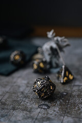 Focus on d20 die. Blurred background with monster miniatures for board games. Dice game, RPG	