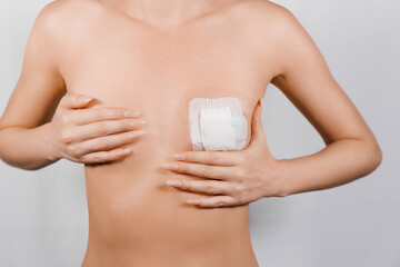 woman's breast covered with adhesive tape after surgery to correct a congenital anomaly.