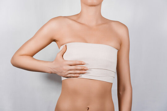 Unrecognizable Woman Showcases Her Chest with Elastic Bandage After Surgery for Congenital Anomaly Repair.
