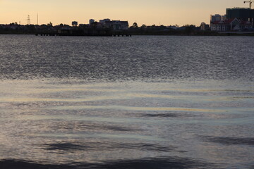 Golden sunlight reflects on tranquil river water under an expansive sky