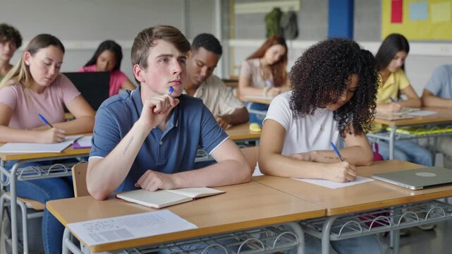 Focused High School student doing test exam, thinking ideas and writing text - Education Concentration - Powered by Adobe