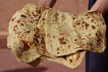 Hands holding moroccan msemmen, Traditional moroccan flatbread