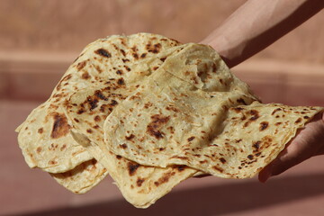 Hands holding moroccan msemmen, Traditional moroccan flatbread