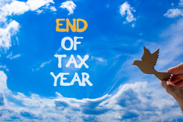 End of tax year symbol. Concept words phrase End of tax year on beautiful blue sky. Businessman's...