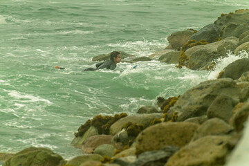 Surfer coming out of water after surfing on cloudy morning
