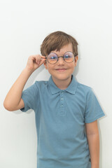 Fototapeta premium Little Boy in Blue Polo T-shirt on White Background, Child Student in Round Glasses