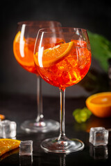 Aperol spritz cocktail in glass with fresh orange on dark background