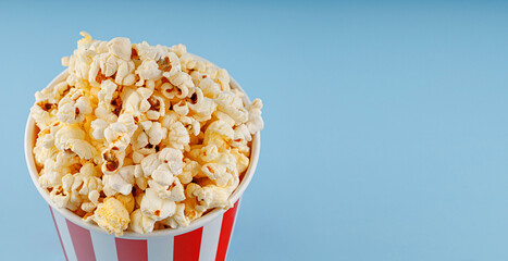 Classic red striped popcorn cardboard cup on blue background