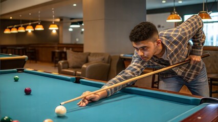 Young man aiming cue during billiards game