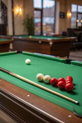 Billiard table with cue and balls, green surface background.