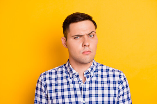 Photo of distrustful suspicious face young man isolated on yellow color background