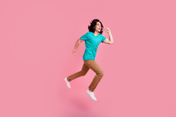 Full body side profile view young happy man wear t-shirt casual clothes jump high run fast hurry up isolated on pastel background studio