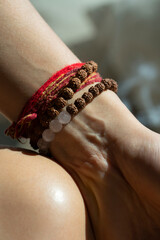 Rudraksha and rose quartz bracelets on woman's hand. High quality photo