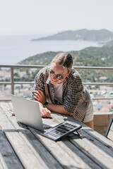 digital nomad woman working remotely from a cozy kitchen during breakfast. Remote work,...