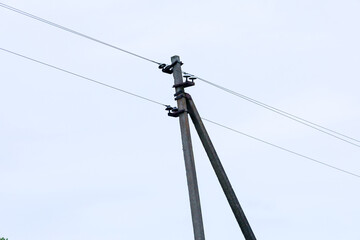 The photograph shows an electrical pole with wires against a clear sky. This is a typical element...